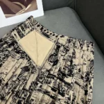 Jupe mi-longue plissée Dior Femme en gabardine de coton beige et noire à motif Paris allover